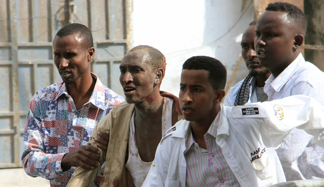 Petugas membawa korban dari serangan bom mobil di Mogadishu, Somalia, Rabu (25/1). Kelompok Alshabaab mengklaim berada di balik serangan tersebut. (AP Photo)