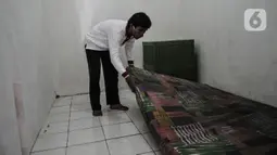 Anggota Lembaga Keswadayaan Masyarakat (LKM) merapikan kamar isolasi COVID-19 di RW 05 Kelurahan Kuningan Barat, Jakarta, Kamis (27/8/2020). Dari 16 kamar indekos, 4 di antaranya dijadikan sebagai ruang isolasi yang telah disterilisasi. (merdeka.com/Iqbal S. Nugroho)
