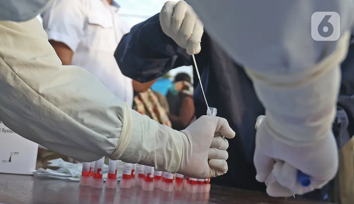 Petugas medis mengambil sampel penumpang KRL Commuter Line saat tes swab dengan metode polymerase chain reaction (PCR) di Stasiun Bekasi, Selasa, (5/5/2020). Pemkot Bekasi melakukan tes swab secara massal setelah tiga penumpang KRL dari Bogor terdeteksi virus corona. (Liputan6.com/Herman Zakharia)