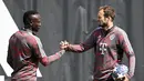 Bek Bayern Munchen Daley Blind (kanan) menyambut rekan setimnya Sadio Mane (kiri) pada awal sesi latihan menjelang perempat final Liga Champions menghadapi Manchester City di Munich, Jerman bagian selatan, Senin (10/4/2023). (Photo by Christof STACHE / AFP)