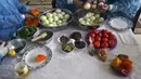 Para wanita membuat maftoul atau couscous di Khan Yunis, Jalur Gaza, Palestina, 10 Januari 2022. Agar beraroma sedap dan terasa hangat, maftoul biasa ditambahkan dengan buncis dan bawang. (SAID KHATIB/AFP)