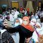 Khofifah saat menyambut kedatangan jemaah haji Jatim kloter pertama dan kedua di Surabaya. (Dian Kurniawan/Liputan6.com)