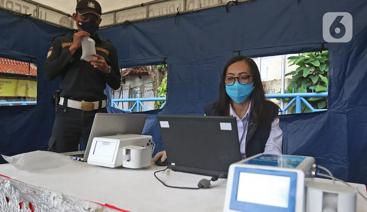 Petugas dites dengan GeNose C19 di Terminal Kampung Rambutan, Jakarta, Minggu (24/1/2021). Menhub akan mengimplementasikan penggunaan GeNose C19 sebagai alat pendeteksi COVID-19 pada calon penumpang di terminal dan stasiun kereta. (Liputan6.com/Herman Zakharia)