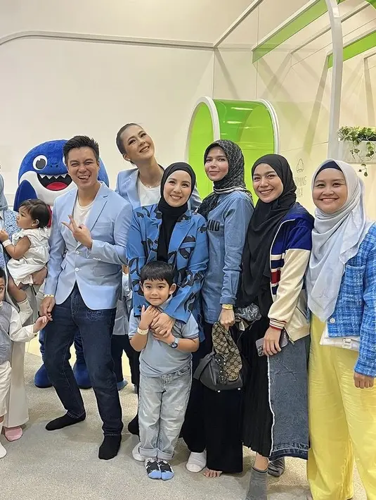 Irish Bella tampil mengenakan outer biru brokat serasi dengan kerudungnya. Dipadukan kemeja lengan panjang putih dan celananya.  [@tya_ariestya]