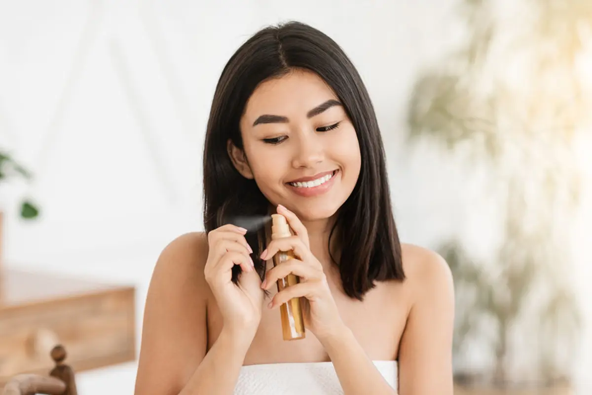 perempuan semprot minyak rambut wangi