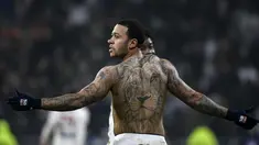 Penyerang Memphis Depay menunjukkan tato Singanya usai mencetak gol ke gawang PSG pada lanjutan Liga Prancis di stadion Grupama, Decines-Charpieu (21/1). Gol eks striker Manchester United ini membawa Lyon menang 2-1 atas PSG. (AFP Photo/Jeff Pachoud)