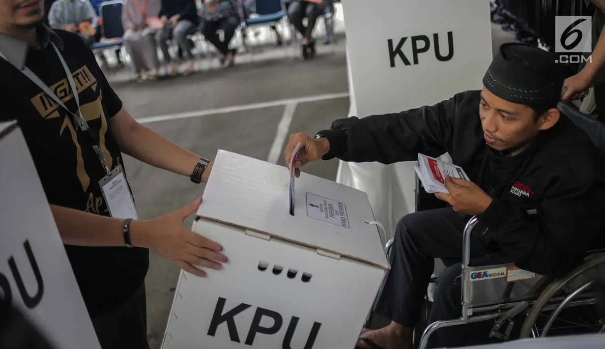 Penyandang disabilitas memasukkan surat suara ke dalam kotak saat simulasi pemungutan dan penghitungan suara Pemilu di halaman Gedung KPU, Jakarta, Selasa (12/3).  Simulasi untuk merepresentasikan pemungutan suara di TPS. (Liputan6.com/Faizal Fanani)