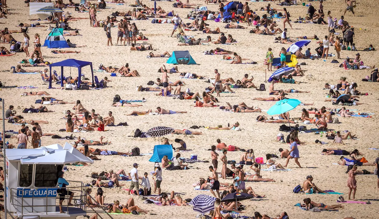 Orang-orang mengunjungi pantai Bondi di Sydney, Australia pada 5 Oktober 2020. Kerumunan warga dan aktivitas yang ramai ini membuat penerapan jarak sosial menjadi nyaris mustahil dilakukan.  (Photo by DAVID GRAY / AFP)
