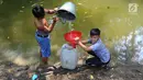 Dua anak Kampung Gamblok mengambil sisa air Kali Cihoe, Desa Ridomanah, Bekasi, Jawa Barat, Kamis (15/8/2019). Kemarau panjang sejak awal Ramadan memaksa warga mencari sisa air untuk diminum.