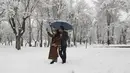 Pasangan berselfie ketika mereka menikmati salju di sebuah taman di Teheran utara, Iran (19/1/2020). Salju tebal menutupi jalan-jalan Teheran, menyebabkan penundaan penerbangan dan munutup sekolah, kata pihak berwenang di ibukota Iran. (AP Photo / Vahid Salemi)