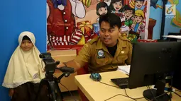 Petugas Disdukcapil Kota Tangerang Selatan melakukan pembuatan Kartu Identitas Anak (KIA) di tempat makan siap saji kawasan Bintaro Tangerang Selatan, Selasa (26/2). (Merdeka.com/Arie Basuki)