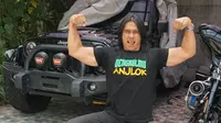 Agung Hercules memamerkan otot tangan dengan gaya andalannya di depan sebuah mobil. Agung masih memiliki tubuh yang besar dan berotot sebelum dirinya terserang kanker otak. (Liputan6.com/agunghercules88)