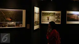 Pengunjung mengamati karya foto pada Pameran Papuaku Papuamu di Kuningan City, Jakarta, Selasa (27/12). Sebanyak 117 karya para pewarta foto ditamplkan dalam 40 bingkai. (Liputan6.com/Helmi Fithriansyah)