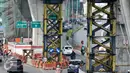 Kendaraan melintas di bawah proyek pembangunan jembatan layang di Jalan Kapten P. Tendean, Jakarta Selatan, (14/7). Aktivitas pembangunan jalan layang busway Tendean-Ciledug masih belum berjalan penuh pasca libur Lebaran. (Liputan6.com/Yoppy Renato)