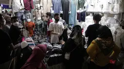 Pedagang melayani pembeli perlengkapan ibadah di Pasar Tanah Abang Blok A, Jakarta, Senin (4/4/2022). Penjualan busana muslim seperti mukena, kerudung, sajadah dan sarung mengalami peningkatan di bulan Ramadhan. (Liputan6.com/Faizal Fanani)