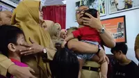Wali Kota Makassar menggendong bocah korban penyekapan oleh ibu asuhnya (Liputan6.com/ Eka Hakim)