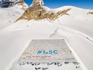 Kartu pos raksasa terbuat lebih dari 125.000 kartu pos yang dikumpulkan untuk memecahkan Rekor Dunia Guinness di Jungfraufirn, Swiss, 16 November 2018. Kartu pos tersebut berisi pesan-pesan menentang perubahan iklim. (Valentin Flauraud/Keystone via AP)