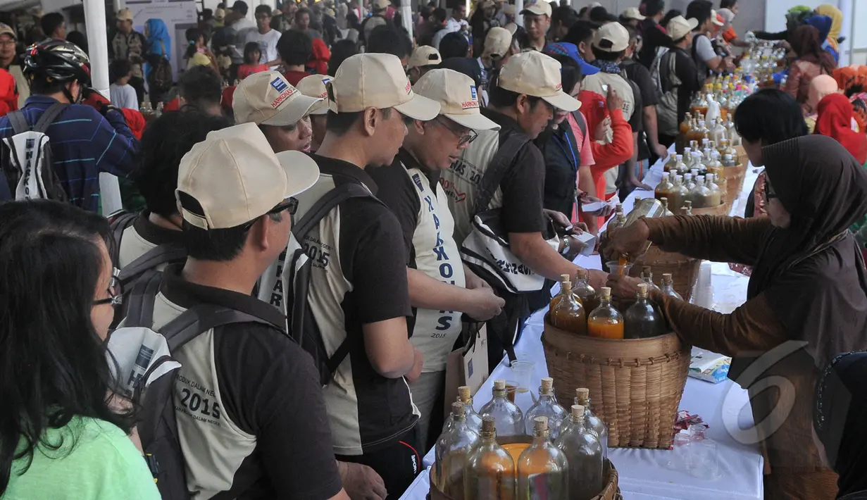Ratusan orang mengantri untuk mendapatkan jamu saat memperingati Hari Konsumen Nasional di Lapangan Parkir Gedung Sarinah, Jakarta, Minggu (10/5/2015). (Liputan6.com/Herman Zakharia) 