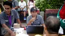 Petugas memberikan penjelasan kepada warga yang mendaftarkan namanya di posko KPUD DKI di kawasan Bundaran HI, Jakarta, Minggu (26/3). KPUD membuka posko pemeriksaan data pemilih terdaftar untuk Pilkada DKI 2017 putaran kedua. (Liputan6.com/Faizal Fanani)