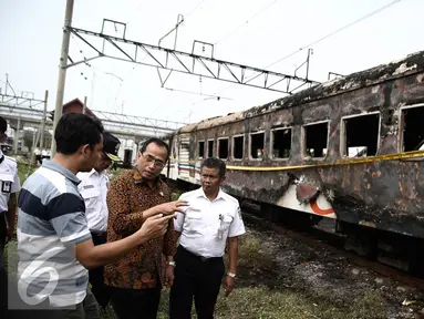 Menhub Budi Karya menyimak keterangan warga saat meninjau lokasi terbakarnya dua gerbong kereta Kerta Jaya kelas Ekonomi di dekat Stasiun Tanjung Priok, Jakarta, Kamis (25/8). (Liputan6.com/Faizal Fanani)