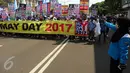 Massa buruh dan pekerja dari berbagai daerah membentangkan spanduk dalam peringatan May Day atau Hari Buruh Internasional di Jalan MH Thamrin, Jakarta, Senin (1/5). Massa buruh berjalan sambil membawa poster-poster tuntutan. (Liputan6.com/Johan Tallo)
