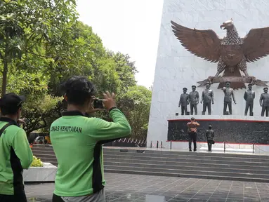 Pengunjung berfoto di depan Monumen Pancasila Sakti, Jakarta Timur, Selasa (1/10/2024). (Liputan6.com/Herman Zakharia)