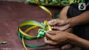 Pedagang menjalin pita untuk membuat pernak-pernik ketupat hias di Pasar Asemka, Jakarta, Selasa (4/5/2021). Pedagang mulai menjual pernak-pernik menjelang Lebaran seperti ketupat hias dengan harga mulai dari Rp15.000 hingga Rp60.000 tergantung ukuran. (Liputan6.com/Faizal Fanani)