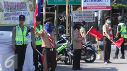 Para anggota pramuka mengatur lalu lintas jalur mudik di Cirebon, Jawa Barat, Jumat (1/7). Sebanyak 3.000-4.000 anggota pramuka Kwartir Daerah dikerahkan untuk membantu polisi dalam memberikan pelayanan kepada para pemudik. (Liputan6.com/Angga Yuniar)