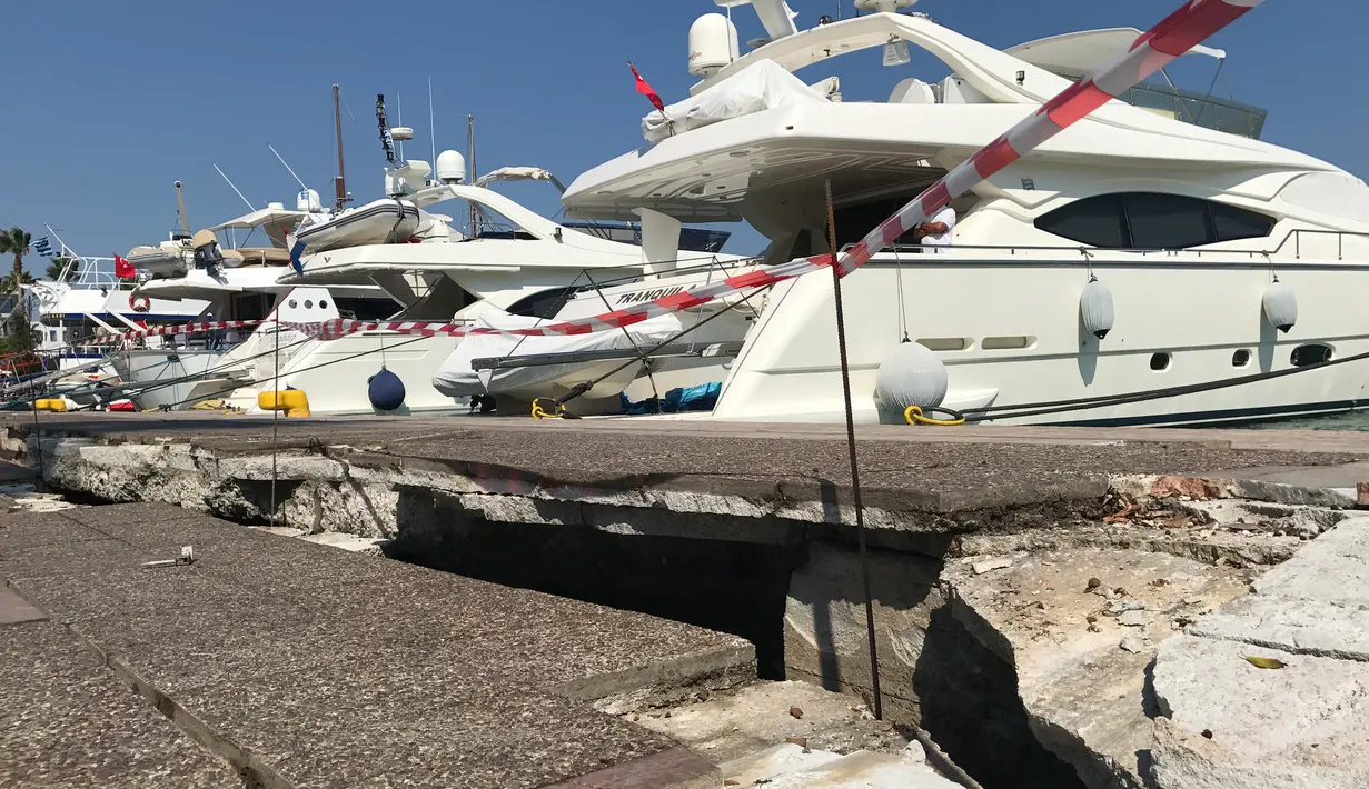 Sebuah celah besar di sepanjang dermaga muncul setelah gempa 6,7 SR mengguncang Kepulauan Yunani, Jumat (21/7). Dan gelombang tsunami berukuran kecil dilaporkan sempat melanda pesisir Turki pascagempa terjadi. (AP/Michael Probst)