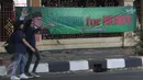 Dua remaja berjalan melintasi spanduk  'Muhaimin for President' di pagar Masjid Sunda Kelapa, Jakarta, Sabtu (12/9). Pemasangan spanduk itu melanggar UU tentang larangan penggunaan tempat ibadah sebagai tempat kampanye. (Liputan6.com/Angga Yuniar)