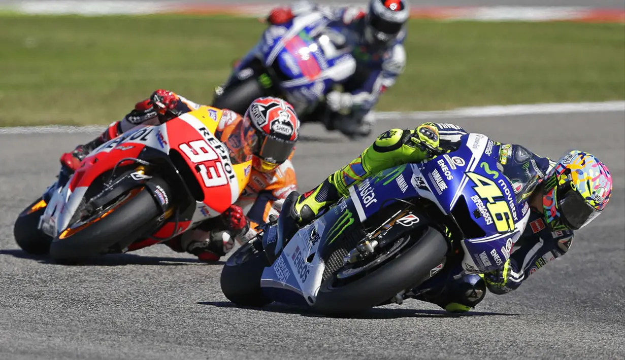 Pembalap Honda MotoGP, Marc Marquez (tengah), menempel ketat laju Valentino Rossi (Yamaha MotoGP) saat berlomba di Grand Prix San Marino, Italia, (14/9/2014). (REUTERS/Max Rossi)