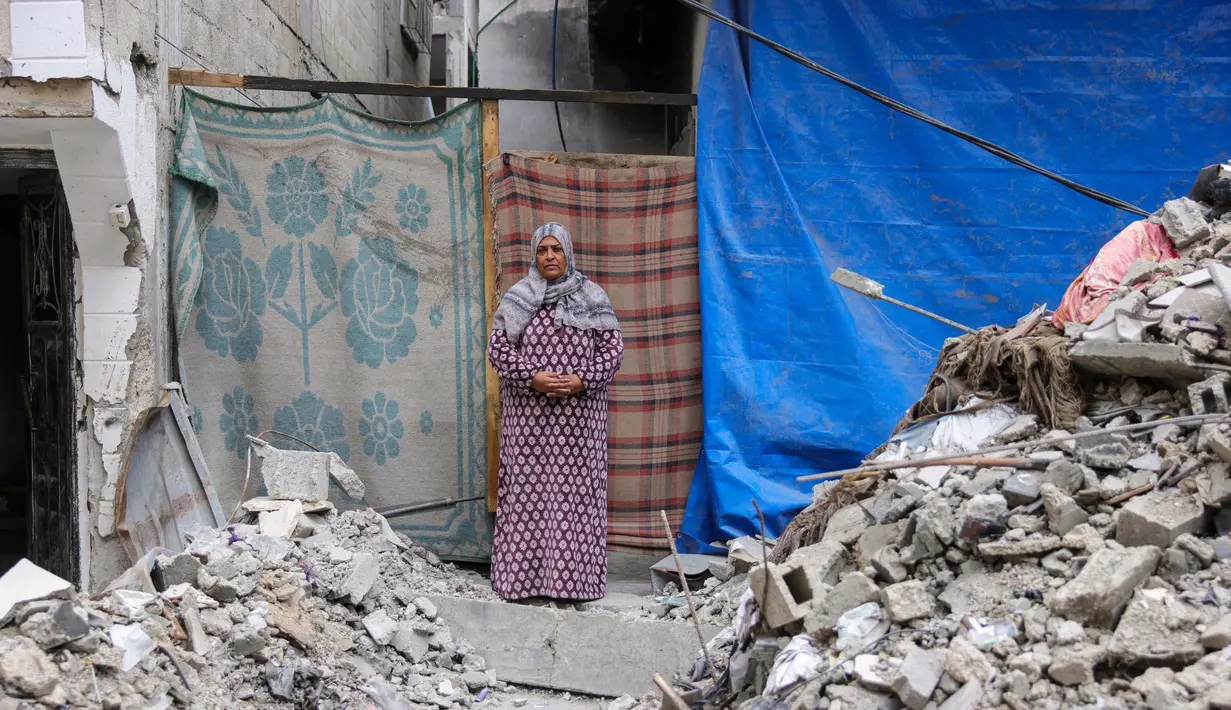 Fadwa Ahmad Taleb, 54 tahun, berpose di depan rumahnya yang hancur di Jabalia, Jalur Gaza utara, pada 9 Februari 2025. (Bashar TALEB/AFP)