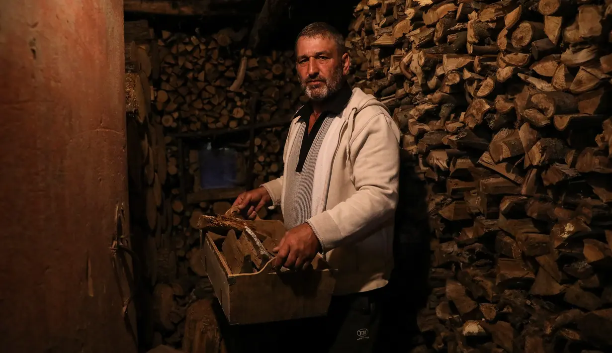 Gheorghe Batca membawa kayu bakar dari gudang ke rumahnya di luar Chisinau, Moldova, 16 Oktober 2022. Krisis energi yang melanda Eropa karena dipicu pemotongan aliran gas alam oleh Rusia di tengah perangnya melawan Ukraina telah memaksa beberapa orang untuk beralih ke kayu bakar untuk menghangatkan diri dalam cuaca yang beranjak dingin. (AP Photo/Aurel Obreja)