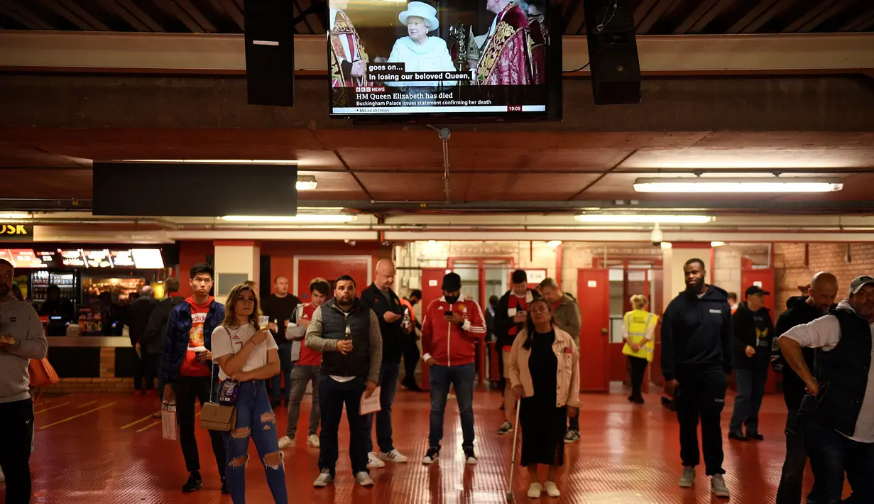 Penonton di Old Trafford tengah menyaksikan berita meninggalnya Ratu Elizabeth II saat menunggu laga Grup E Liga Europa antara Manchester United melawan Real Sociedad, Kamis (8/9/2022) waktu setempat. (AFP/Oli Scarff)