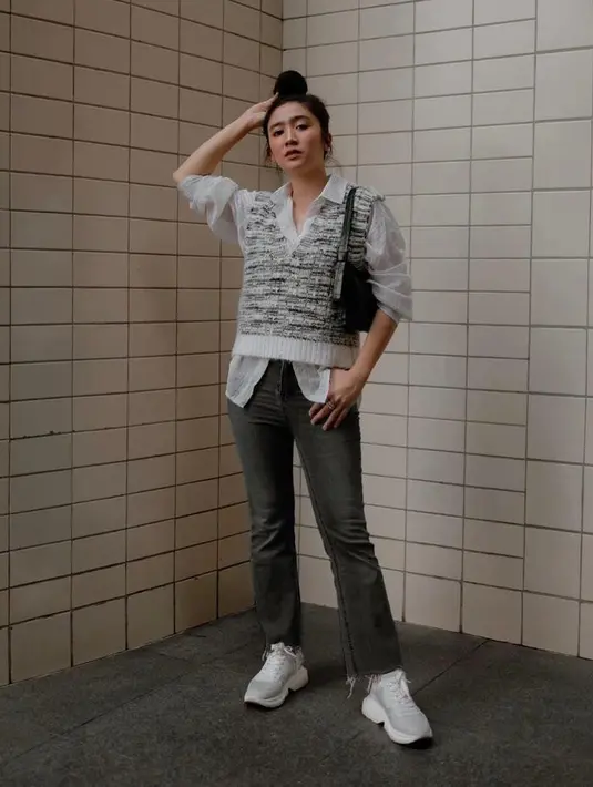 Atau bisa juga tiru gaya Febby Rastanty dengan kemeja putih, knit vest, dan celana jeans ini. (Instagram/febbyrastanty).