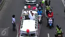 Pasangan Anis Baswesan dan Sandiaga Uno menyapa warga saat berada di mobil karnaval di Thamrin, Jakarta, Sabtu (29/10). Karnaval tersebut merupakan bentuk kampanye damai untuk pemilihan Gubernur DKI Jakarta. (Liputan6.com/Angga Yuniar)