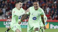 Pemain depan Barcelona asal Brasil #11, Raphinha, merayakan gol kedua timnya bersama gelandang Barcelona asal Spanyol #17, Marc Casado, selama pertandingan liga Spanyol antara RCD Mallorca dan FC Barcelona di stadion Mallorca Son Moix di Palma de Mallorca, Rabu dini hari WIB (4/12/2024). (JAIME REINA/AFP)