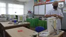 Petugas sekolah sedang membersihkan komputer sebelom murid-murid melakukan pelajaran di  SMKN 51, Jakarta, Rabu (7/4/2021). SMKN 51 melakukan uji coba masuk sekolah dan Uji Sertifikasi Kompetensi (USK) dengan protokol kesehatan yang ketat. (Liputan6.com/Herman Zakharia)
