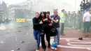 Sejumlah orang menyelamatkan diri ketika kericuhan di depan Stadion Boleyn Ground, London, Selasa (10/5). Kedatangan bus skuat Manchester United disambut dengan lemparan botol dari ratusan suporter West Ham. (Reuters/Eddie Keogh)