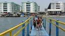 Sejumlah anak bermain pada jembatan kayu yang melintasi tanggul laut Muara Baru di Penjaringan, Jakarta Utara, Minggu (1/9/2019). Anak-anak memanfaatkan sisi tanggul laut raksasa (giant sea wall) sebagai   tempat  bermain alternatif. (merdeka.com/Arie Basuki)
