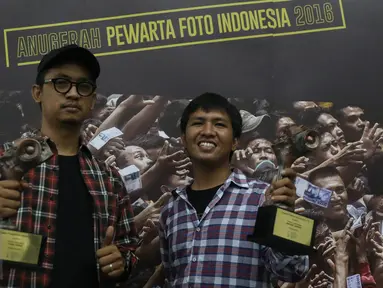 Juara 2 Kategori Spot News pewarta foto Liputan6.com, Faizal Fanani (kiri) dan juara 1 Kategori General News, Immanuel Antonius berpose memegang trofi Anugerah Pewarta Foto Indonesia (APFI) ke-VI di Bandung, Sabtu (9/4). (Liputan6.com/Immanuel Antonius)