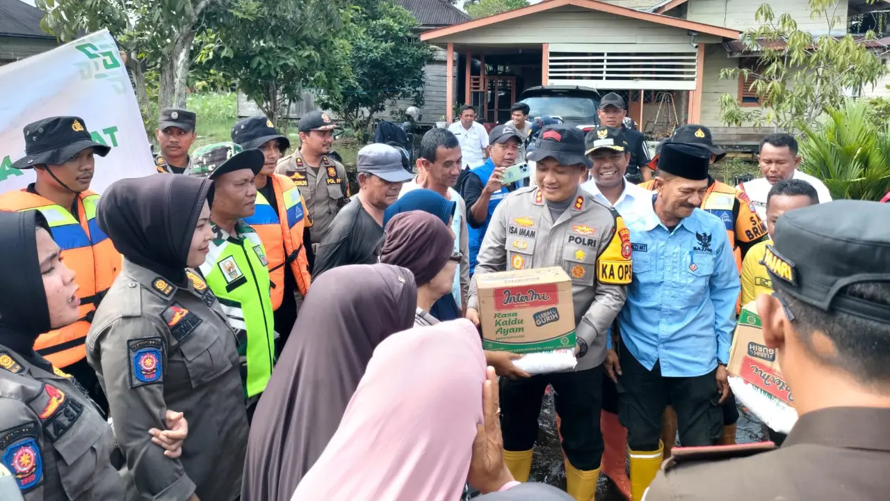 Kapolres Rokan Hilir menyalurkan bantuan kepada korban bencana banjir.