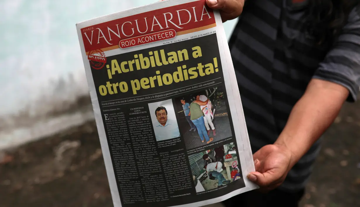 Seorang pria menunjukkan koran yang berisi berita tewasnya wartawan Leobardo Vazquez di Gutierrez Zamora, Meksiko (22/3). Vazquez adalah wartawan ketiga yang dibunuh di Meksiko tahun ini. (AP/Felix Marquez)
