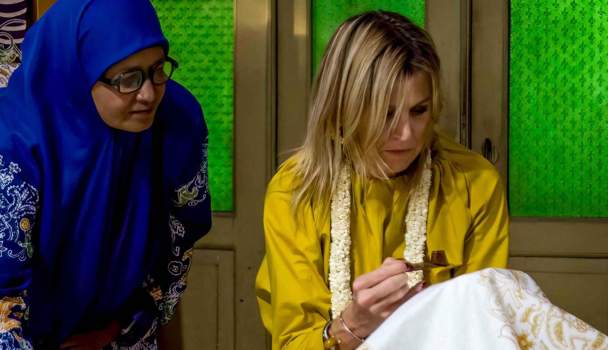 Ia juga dijadwalkan akan bertemu dengan para pemimpin sektor publik dan swasta serta masyarakat Indonesia untuk mempelajari tantangan dan peluang kesehatan keuangan. Tampak dalam foto, Ratu Maxima dari Belanda (kanan), dalam kapasitasnya sebagai Advokat Khusus Sekretaris Jenderal PBB untuk Keuangan Inklusif untuk Pembangunan (UNSGSA), mencoba membatik di Kampung Batik Laweyan, Surakarta, Jawa Tengah, pada Selasa 25 November 2025. (DEVI RAHMAN/AFP)