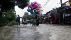 Banjir bukan halangan untuk terus mencari rezeki. Bapak penjual balon ini tetap berjualan walaupun suasana banjir (Liputan6.com/Isna Setyanova).