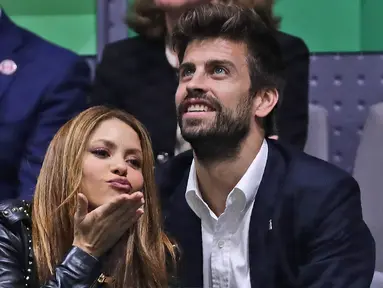 File foto pada 24 November 2019 memperlihatkan penyanyi Kolombia Shakira memberi isyarat ciuman di samping pasangannya, bek Barcelona Gerard Pique saat menonton final Piala Davis di Madrid, Spanyol. Biduk cinta Gerard Pique dengan Shakira akhirnya usai sudah. Keduanya mengumumkan perpisahannya dalam sebuah pernyataan yang dirilis pada 4 Juni 2022. (AP Photo/Manu Fernandez, File)