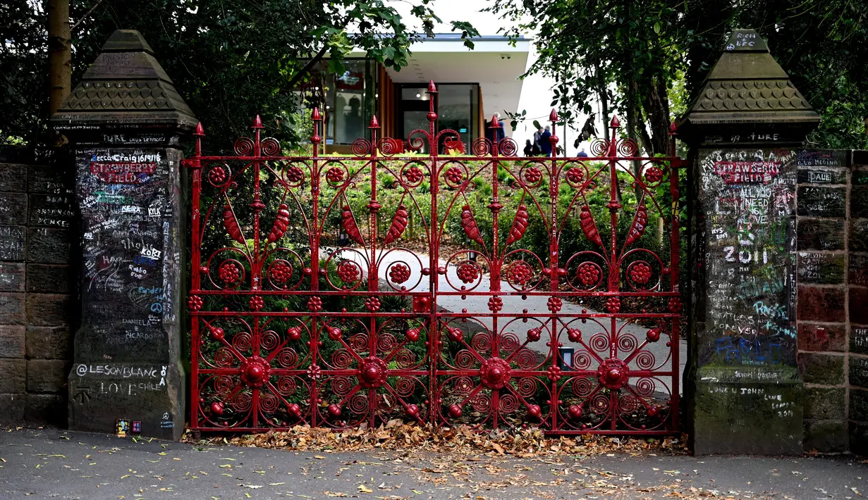 Graffiti digambarkan di gerbang Strawberry Field yang baru dibuka untuk umum di Liverpool, Rabu (18/9/2019). Strawberry Field adalah nama sebuah panti Salvation Army di sekitar sudut rumah masa kecil John Lennon yang menjadi populer dan kini dibuka untuk umum usai 70 tahun ditutup. (Paul ELLIS/AFP)