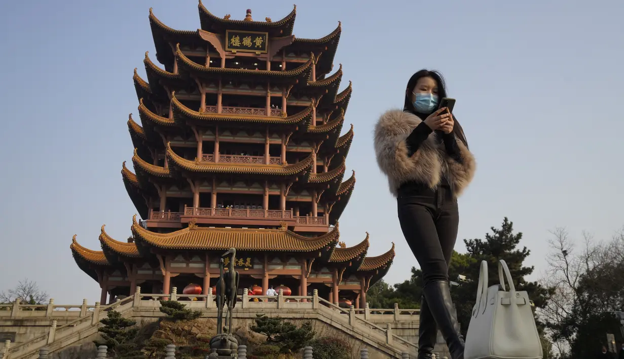 Seorang perempuan bermasker mengunjungi Menara Bangau Kuning yang ikonik di Wuhan di provinsi Hubei, China, Jumat (15/1/2021). Selain masker, orang-orang menjalani kehidupan sehari-hari mereka seperti sebelumnya di Wuhan, tempat pertama kali virus corona COVID-19 terdeteksi. (AP Photo/Ng Han Guan)