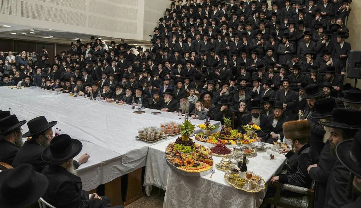 Umat Yahudi ultra-ortodoks dari dinasti Sadigura Hasidic merayakan Hari Raya Tu Bishvat atau Tahun Baru Pohon di Bnei Brak, Israel, 16 Januari 2022. Pada perayaan ini mereka duduk bersama para rabi di sekitar meja panjang dengan hidangan aneka jenis buah-buahan. (AP Photo/Ariel Schalit)