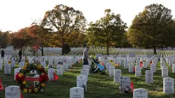 Warga mengunjungi Pemakaman Nasional Arlington saat peringatan Hari Veteran, Arlington, Virginia, AS, Senin (11/11/2019). Rakyat AS memperingati Hari Veteran untuk menghormati mereka yang pernah bertugas di militer AS. (Alex Wong/Getty Images/AFP)